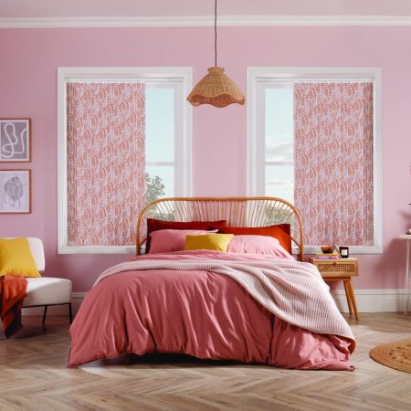 a bedroom with pink walls and a bed and chair